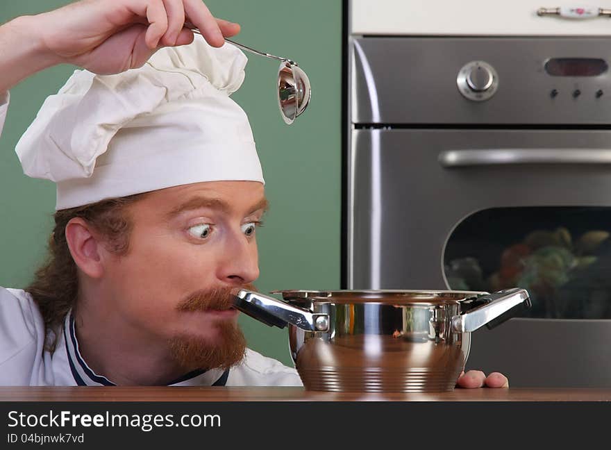 Funny young chef strange looking at pot