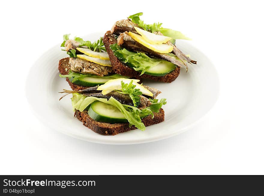 Smoked sardines sandwich with cucumber and whole wheat bread on white plate