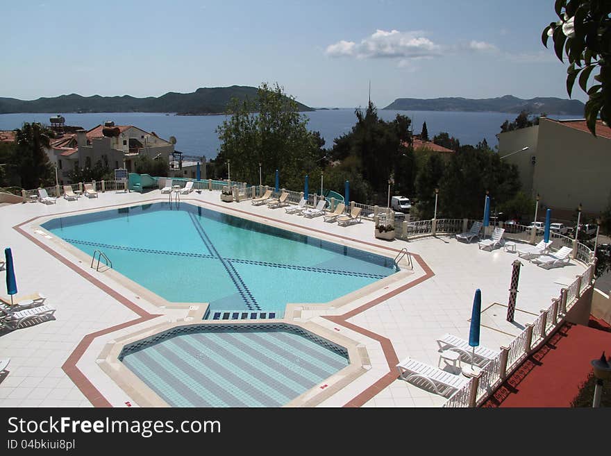 An empty hotel pool in the town of Kas shows the islands in the background, including the Greek Island of Meis. An empty hotel pool in the town of Kas shows the islands in the background, including the Greek Island of Meis