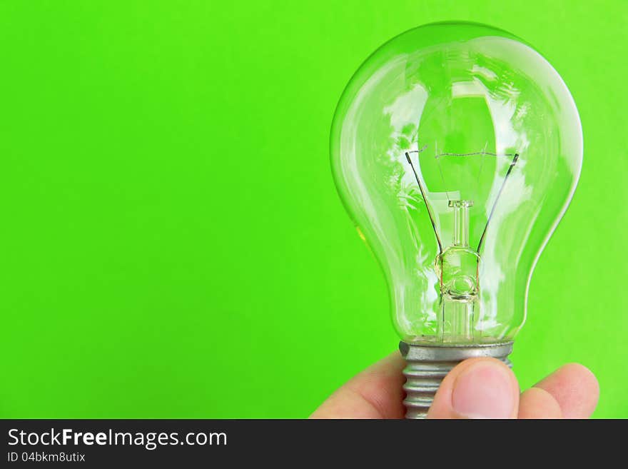 Light blub in hand with green background, eco energy concept