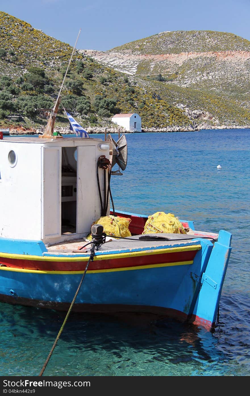 A fishing boat in the harbour of Meis Greece, with a small church at the waters edge. A fishing boat in the harbour of Meis Greece, with a small church at the waters edge.