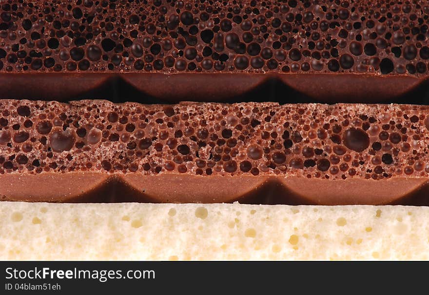 Background of black, brown and milk white blocks of Porous chocolate