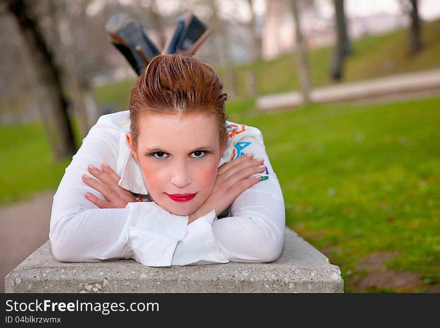 Beautiful middle-aged woman, lying on a garden bench, in outside