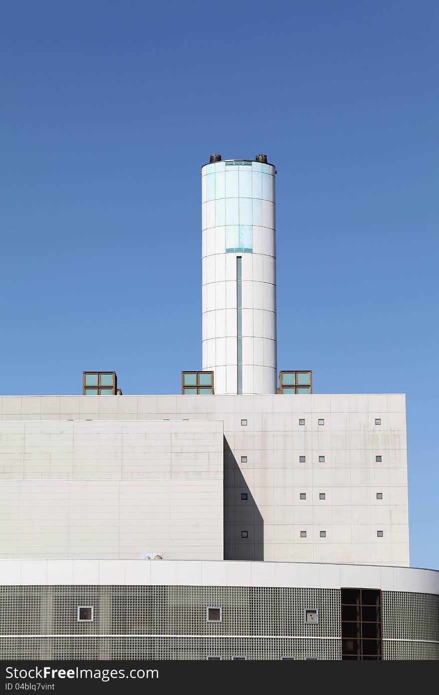 Incineration plant with chimney against blue sky