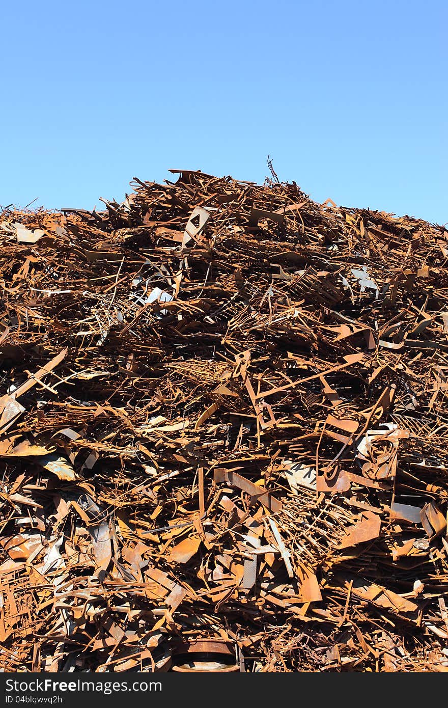 Pile of scrap metal against blue sky