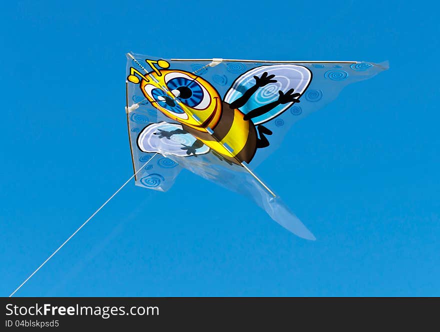 Cartoon bee character kite flying against a bright clear blue sky. Cartoon bee character kite flying against a bright clear blue sky.