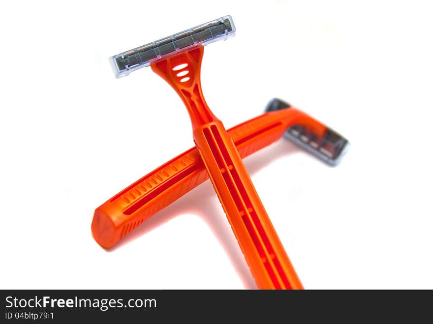 Two orange razor blades close-up on white background