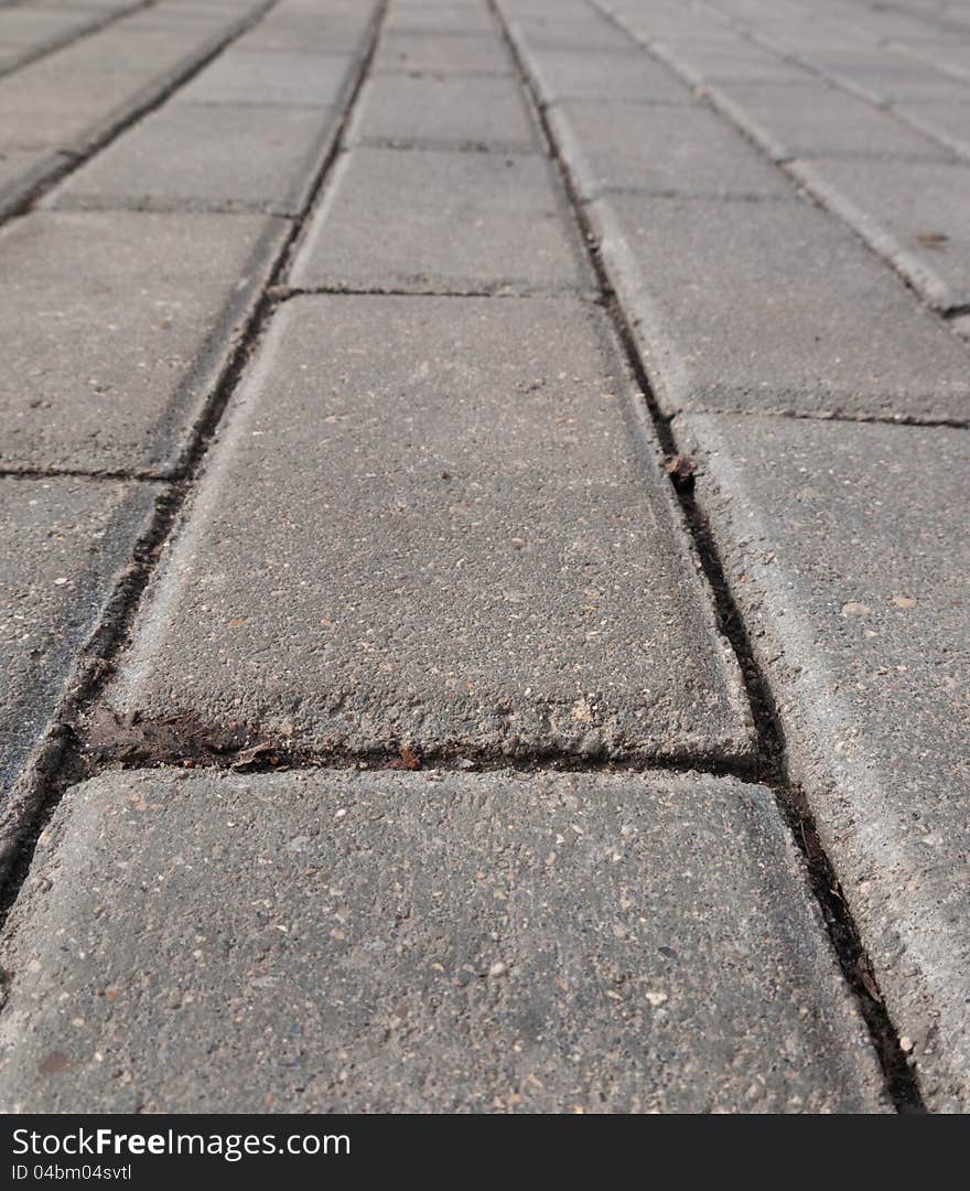 Bricks of a paved road stretching infinitely forward