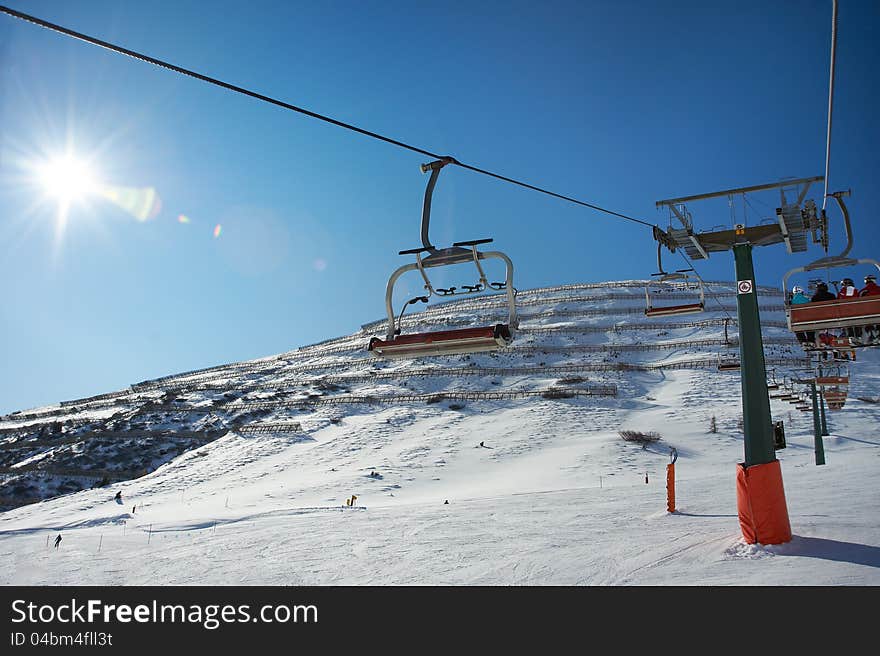 Ski lifts on background of slope with protection from avalanches in sunny day. Ski lifts on background of slope with protection from avalanches in sunny day