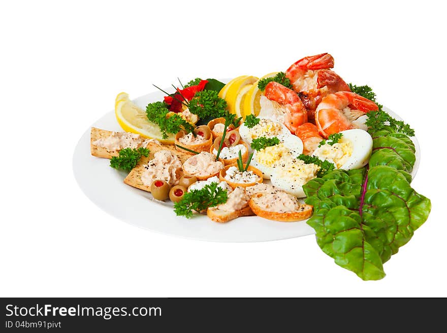 Plate full of orderves, edible flowers and shrimp isolated on a white background. Plate full of orderves, edible flowers and shrimp isolated on a white background