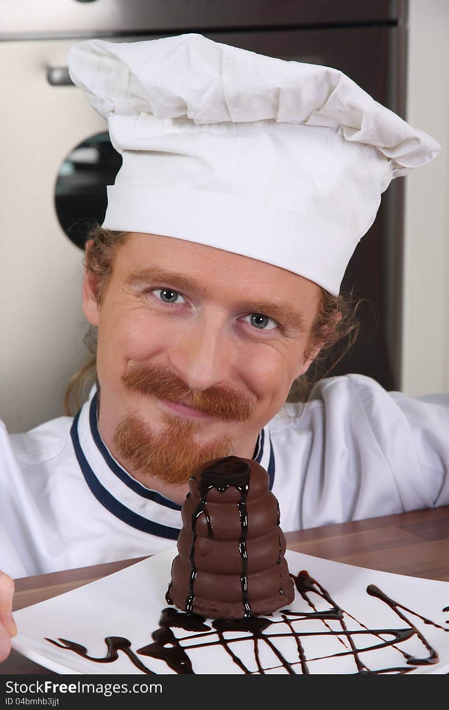 Young chef with piece of cake with chocolate sauce