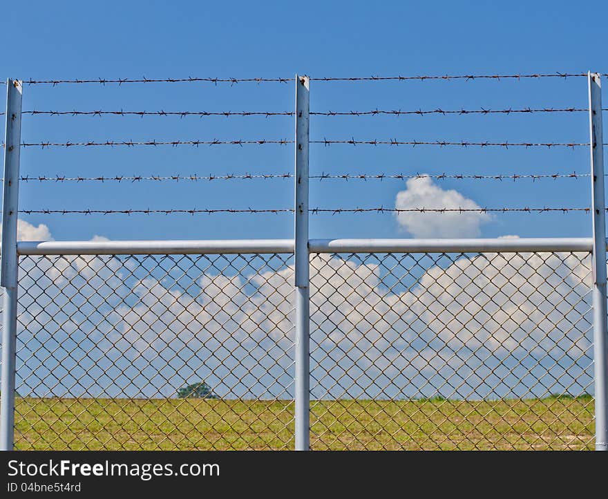 Barbed wire fence and blue sky. Barbed wire fence and blue sky.