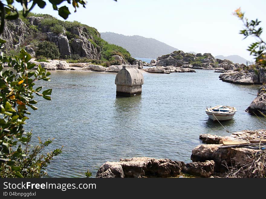 Taken on a walk along the Lycian way to Simena in Turkey. Shows a tomb surroundered by the sea with an old rowing boat in the foreground. Taken on a walk along the Lycian way to Simena in Turkey. Shows a tomb surroundered by the sea with an old rowing boat in the foreground