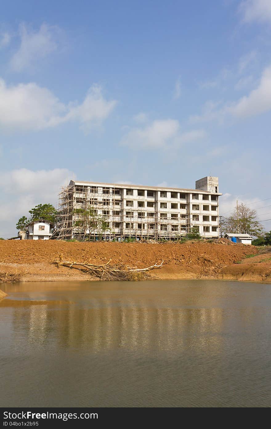 Building construction on land which has a reflection in the pond. Building construction on land which has a reflection in the pond.