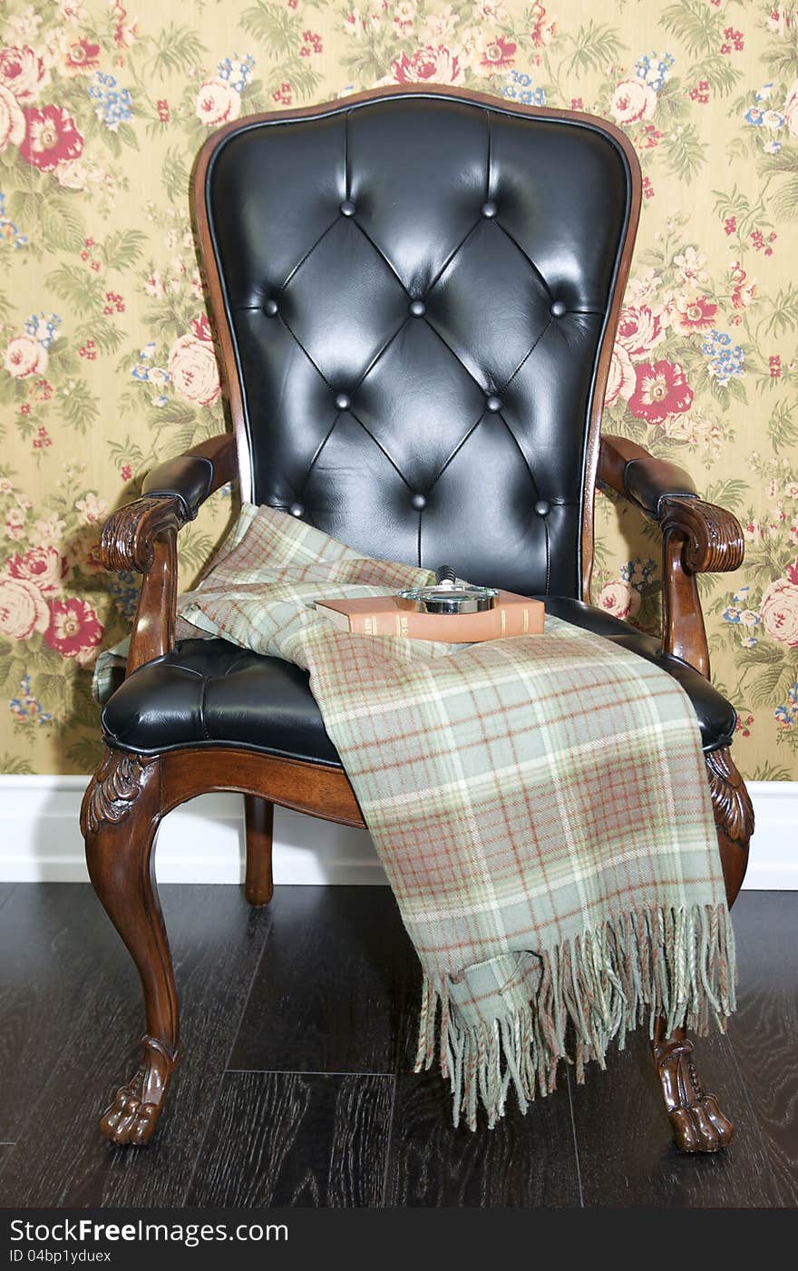 Comfortable chair with a blanket and a book to read