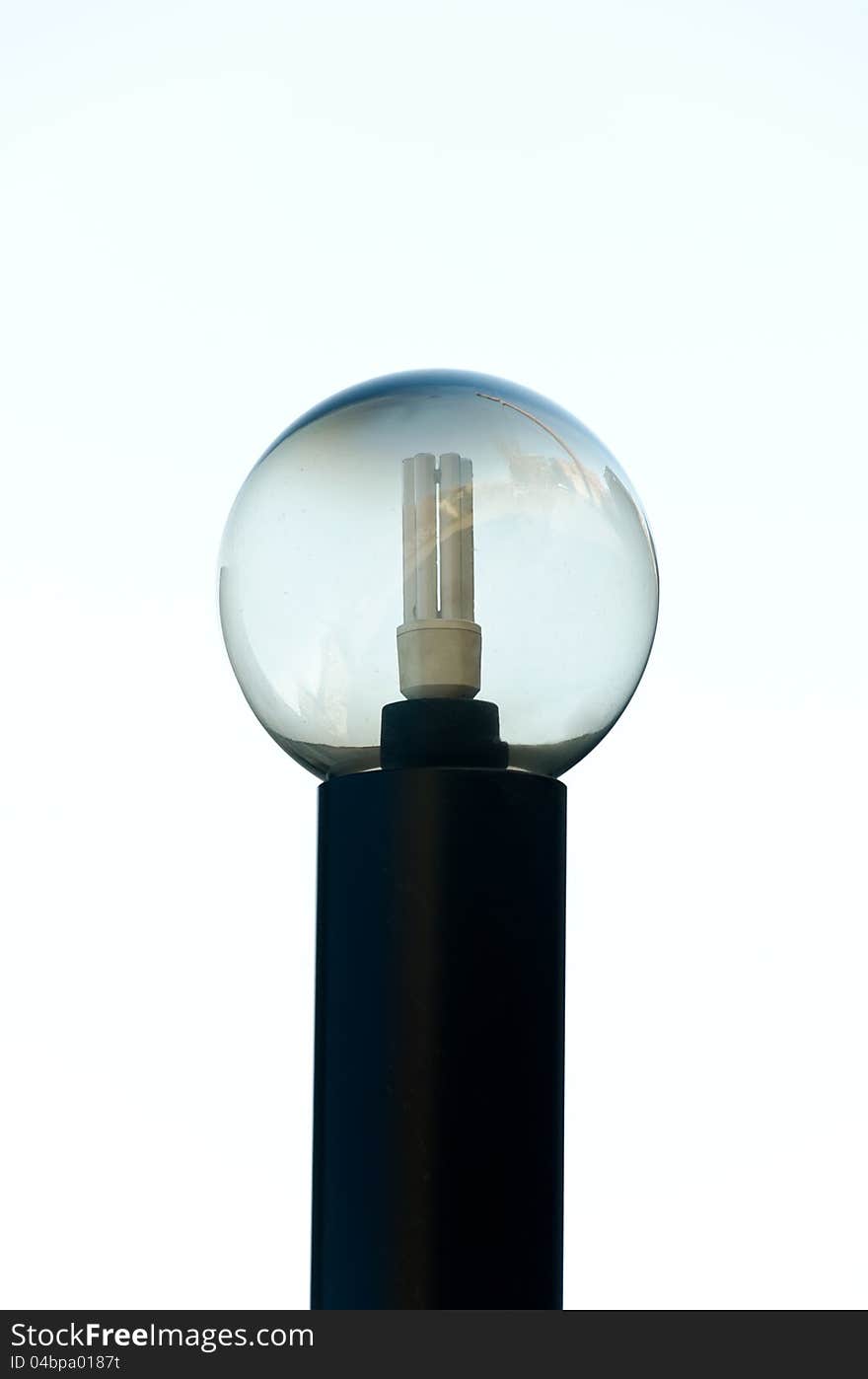 Saving light bulb in a glass sphere with city reflection