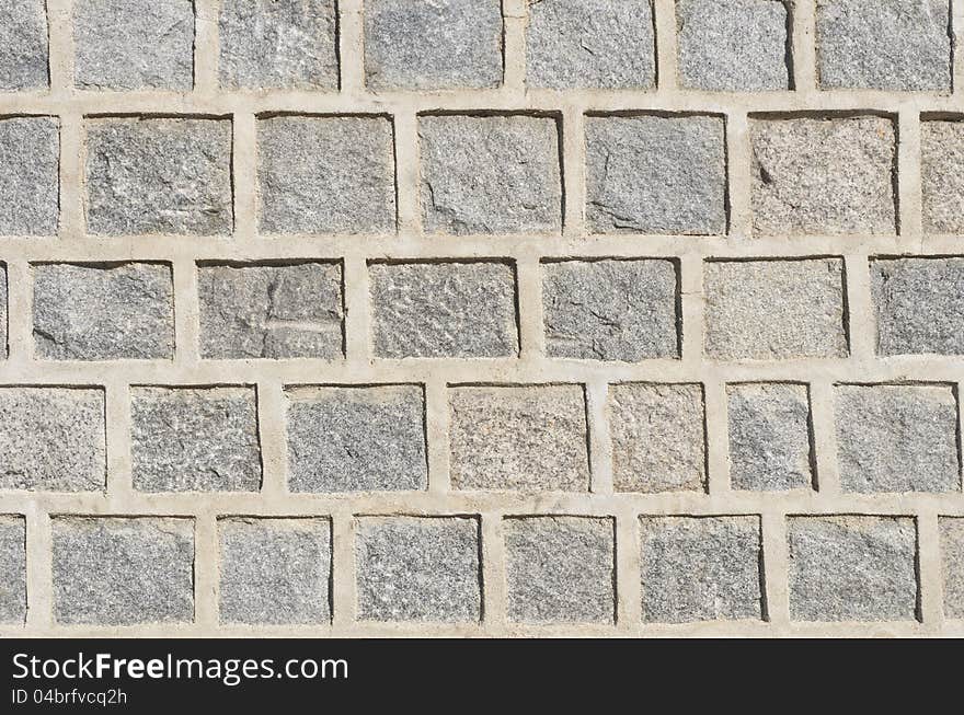 Gray granite stone wall pattern with thick concrete border