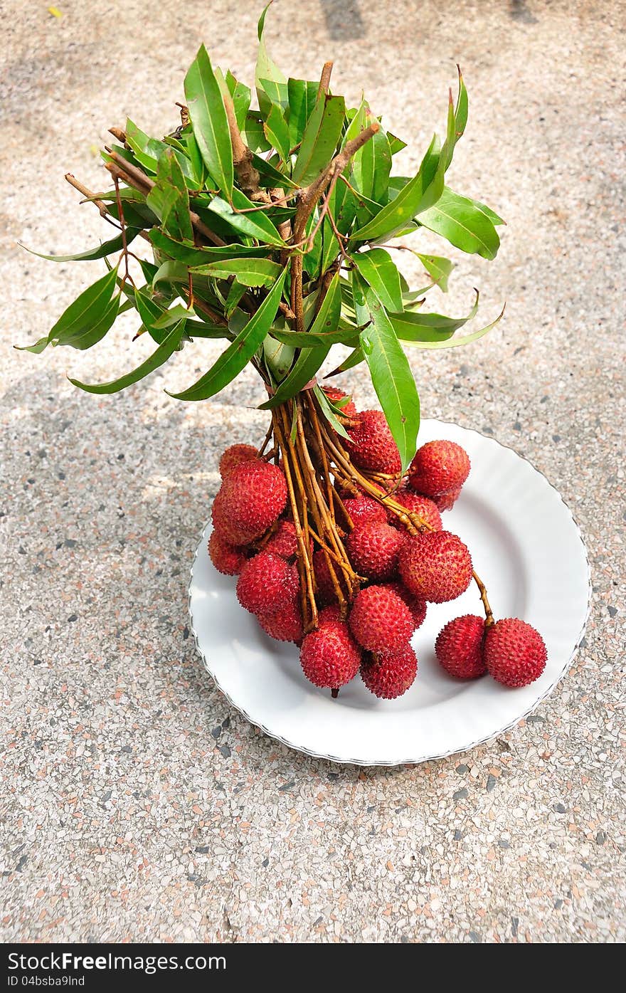 Bunch of fresh lychees on plate, Litchi chinensis