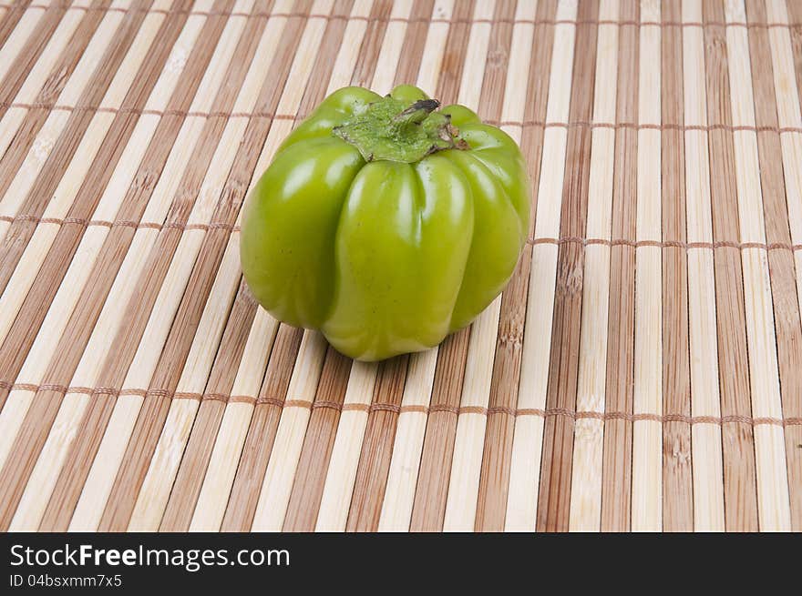 A green pepper on bamboo background