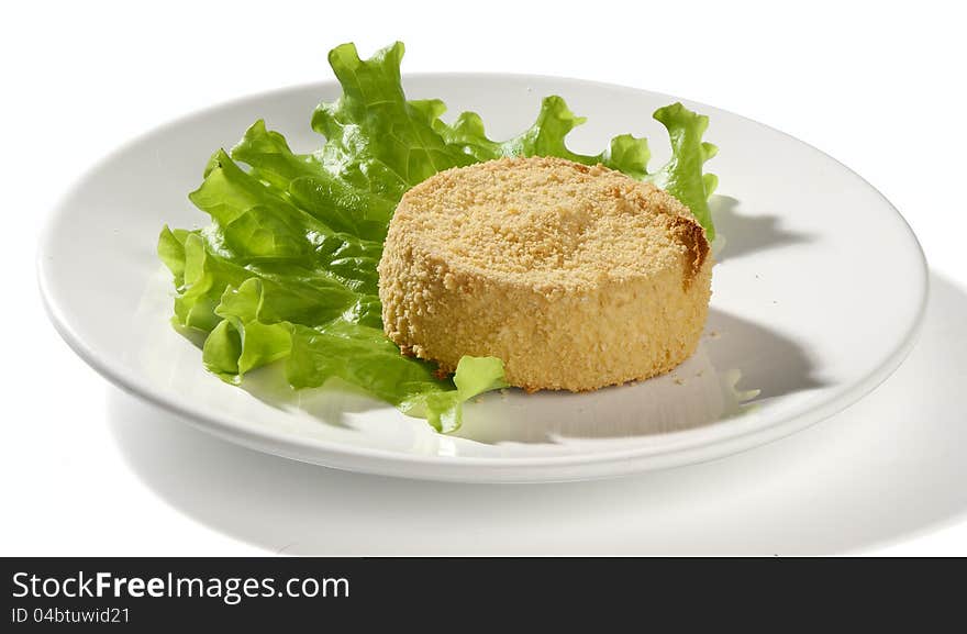 Baked camambert coated with breadcrumbs with lettuce on the plate