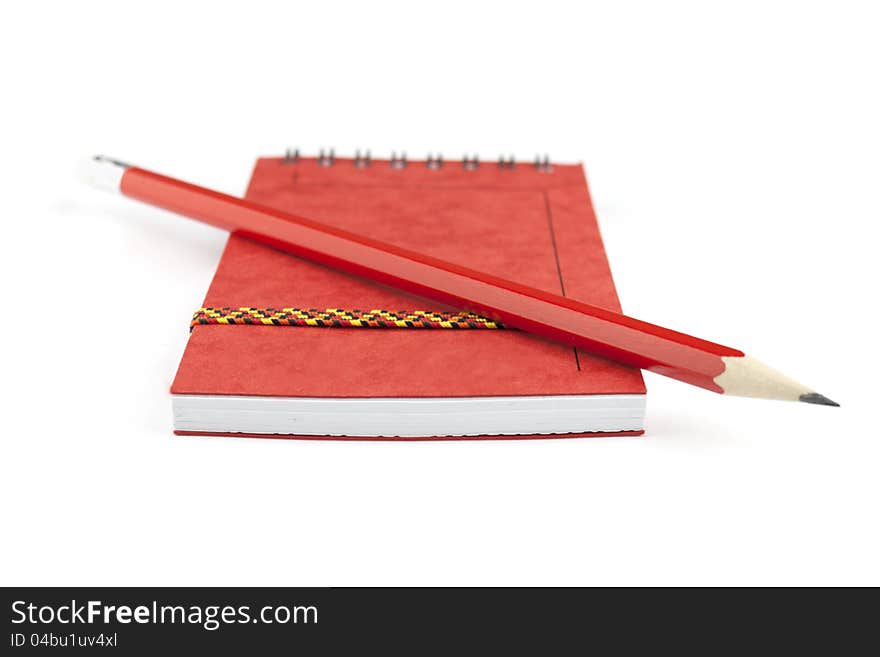 Red closed notepad and pencil isolated on white