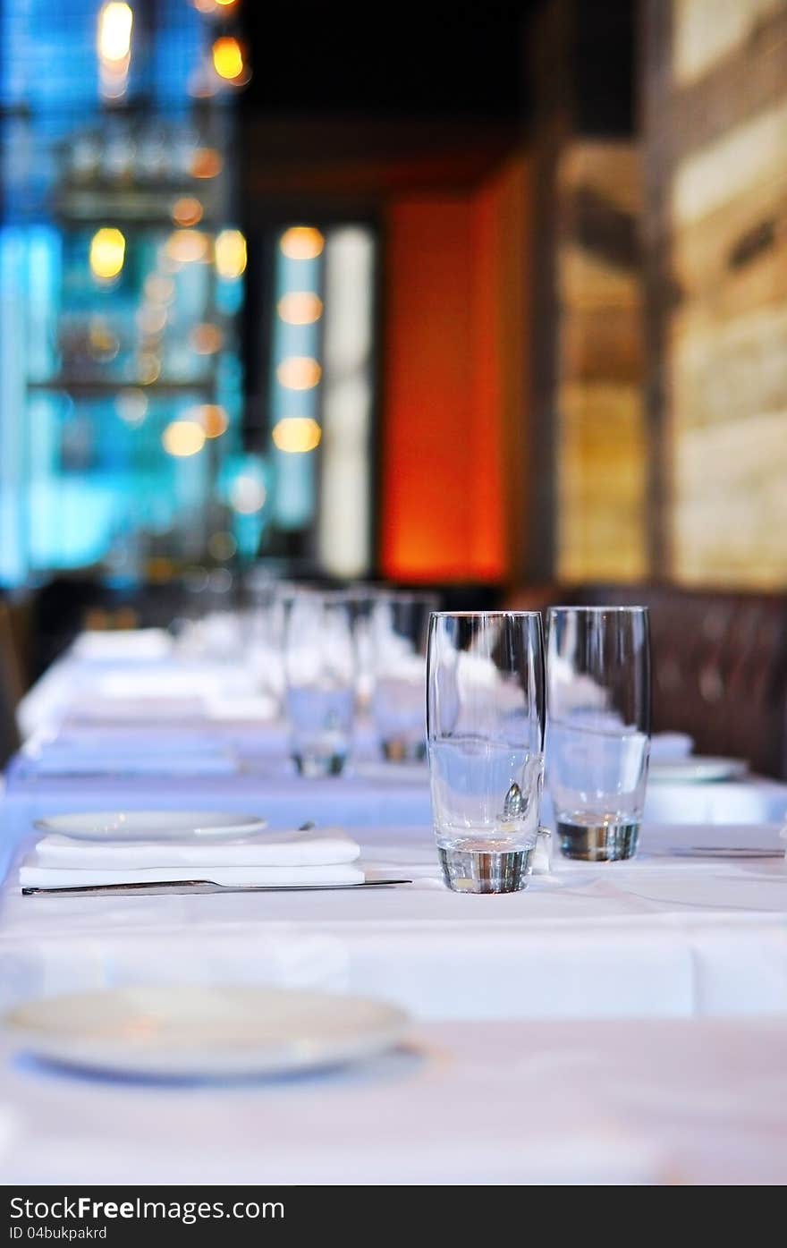 Glasses sit perfectly in line with their place settings on perfectly white tablecloths. Glasses sit perfectly in line with their place settings on perfectly white tablecloths.