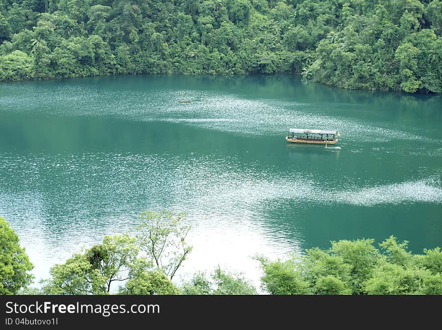 A small boat on blue water. It is a lake in the mountain valley, the water is in blue color.