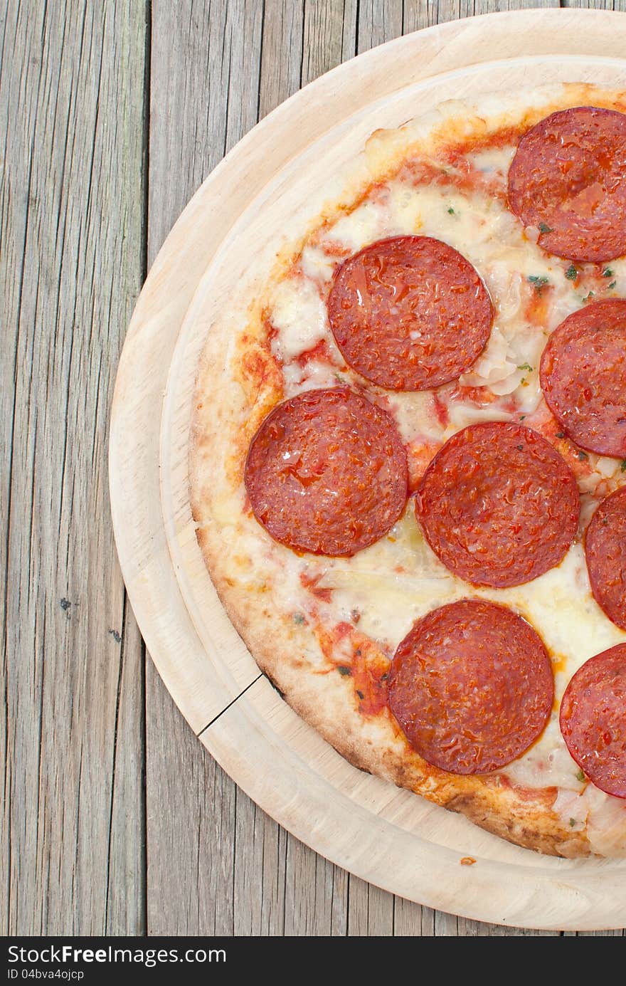 Freshly cooked pepperoni pizza on a wood board