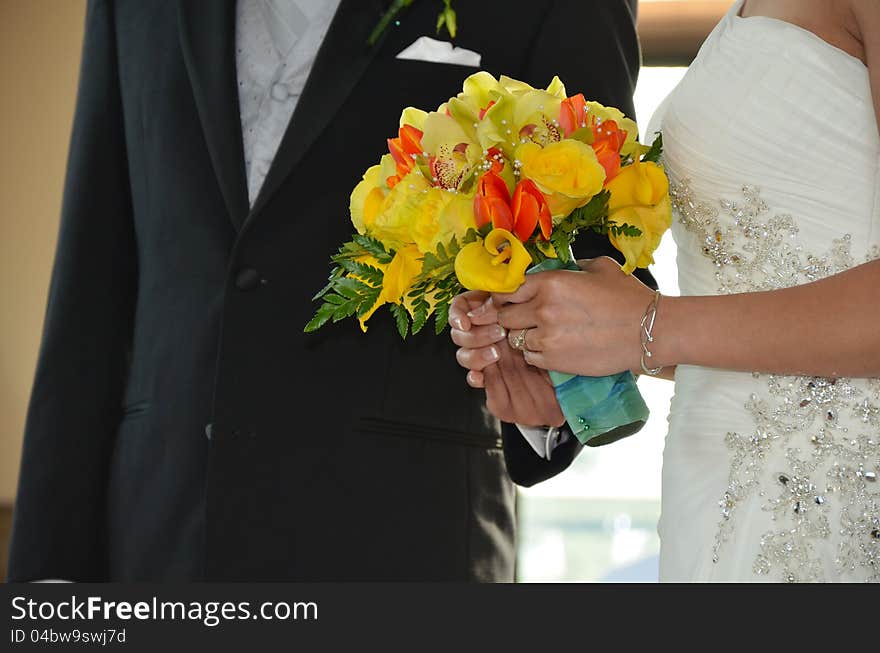 Bride and groom holding floral wedding bouquet