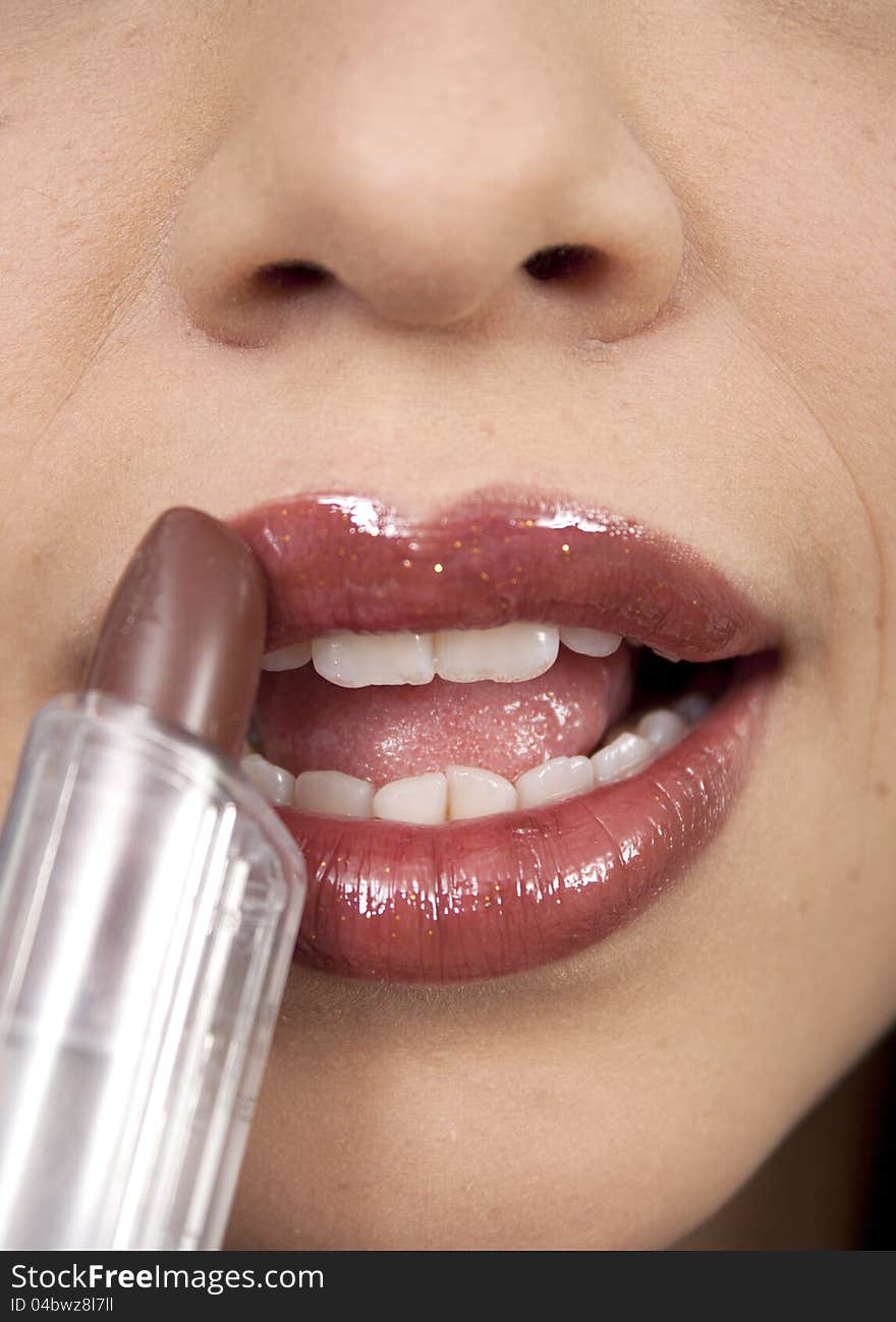 Portrait Of Beautiful Woman Applying Lipstick