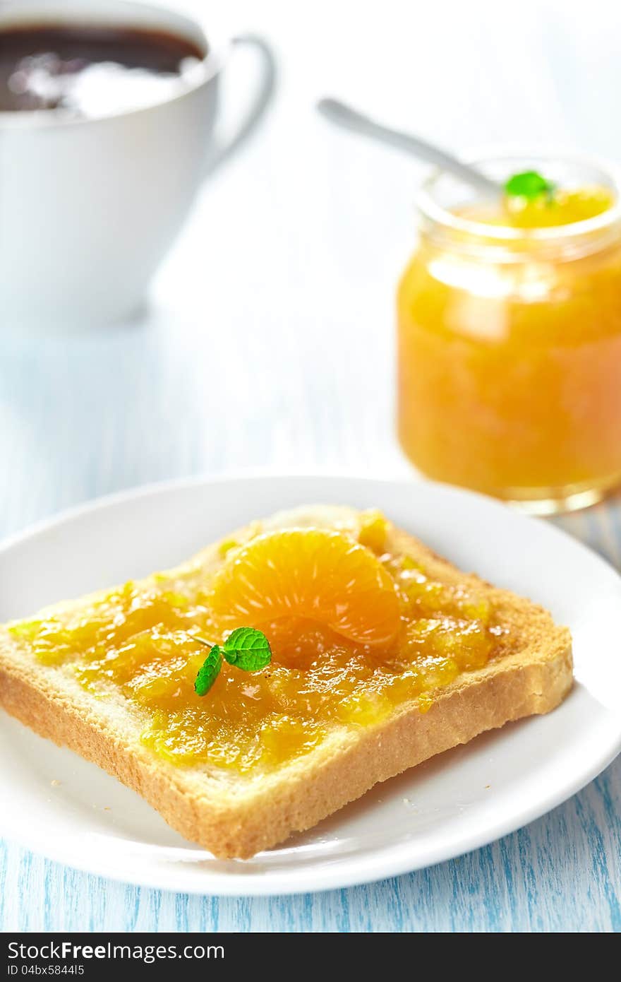 Toast with mandarin marmalade, slice fresh fruit, mint and coffee for breakfast. Toast with mandarin marmalade, slice fresh fruit, mint and coffee for breakfast