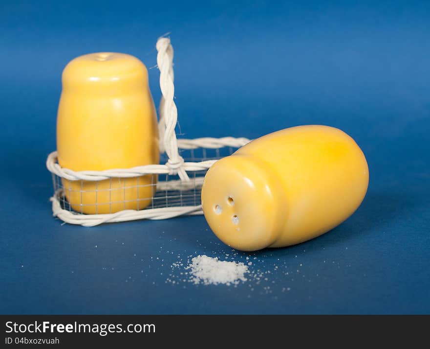 Yellow ceramic salt shaker on a blue background