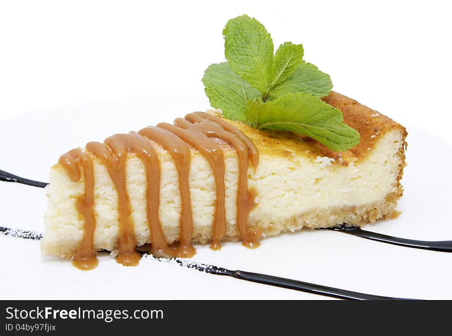 A piece of cheese cake with caramel sauce. A piece of cheese cake with caramel sauce