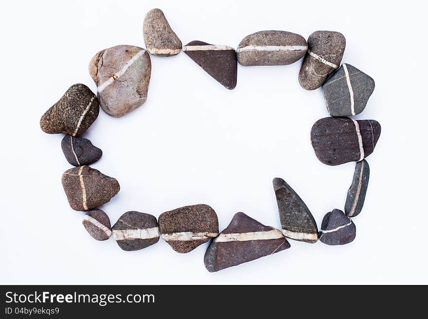 Decoative pebbles with a white vein in the middle arranged to a circle on white background. Decoative pebbles with a white vein in the middle arranged to a circle on white background