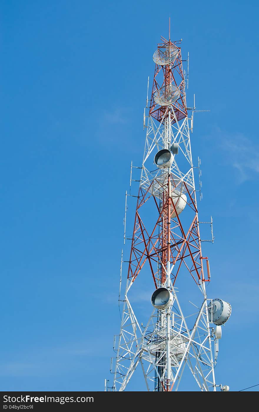 High tower with antenna for communication over blue sky. High tower with antenna for communication over blue sky