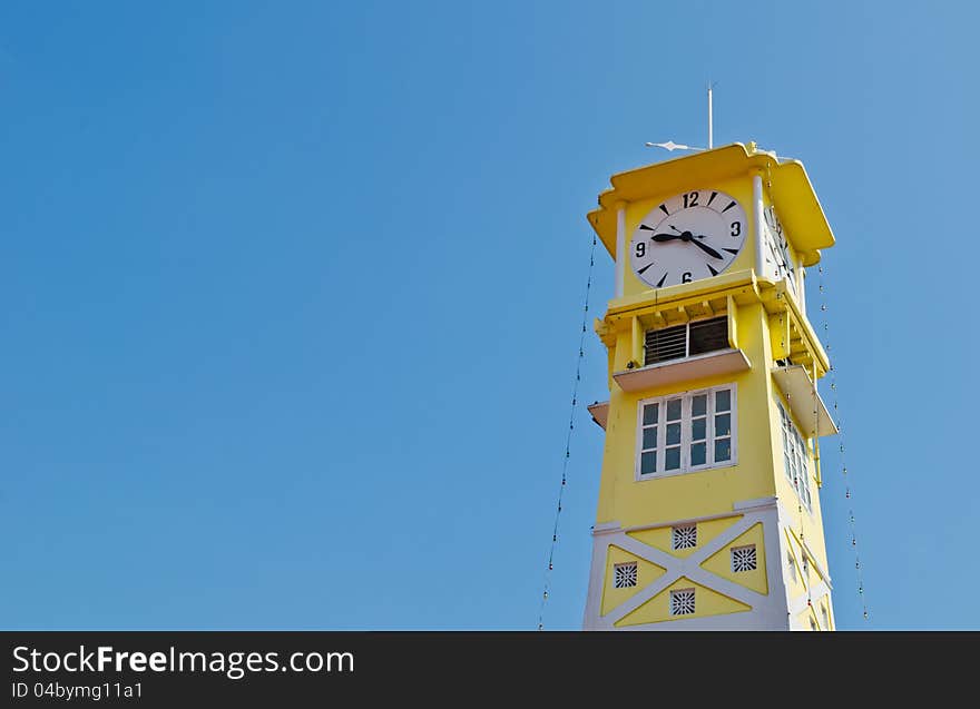 Yellow clock tower with blue sky