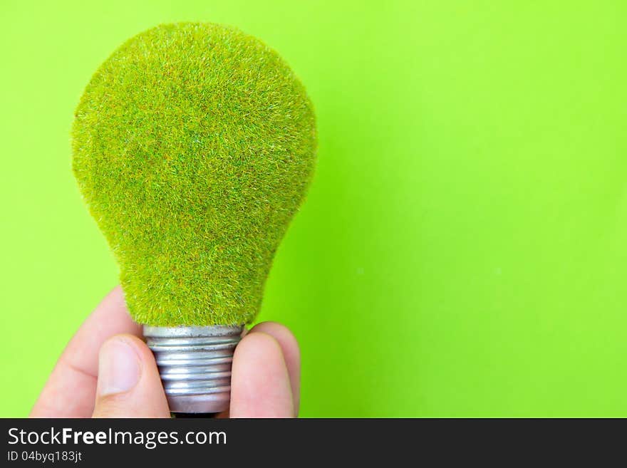 Light blub in hand with green background