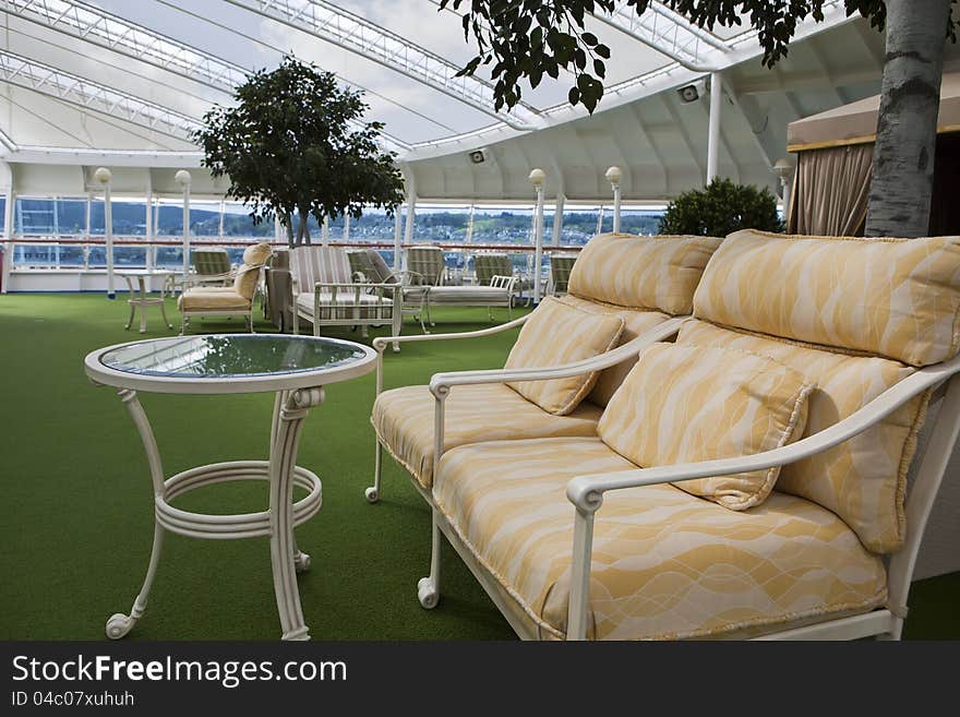 Sunbeds and sofa on open deck spa onboard of the cruise ship on sunny day. Sunbeds and sofa on open deck spa onboard of the cruise ship on sunny day