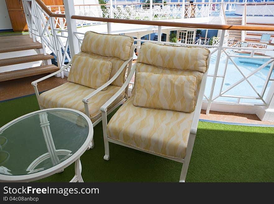 Deckchairs on open deck of the cruise ship with pool on the background. Deckchairs on open deck of the cruise ship with pool on the background