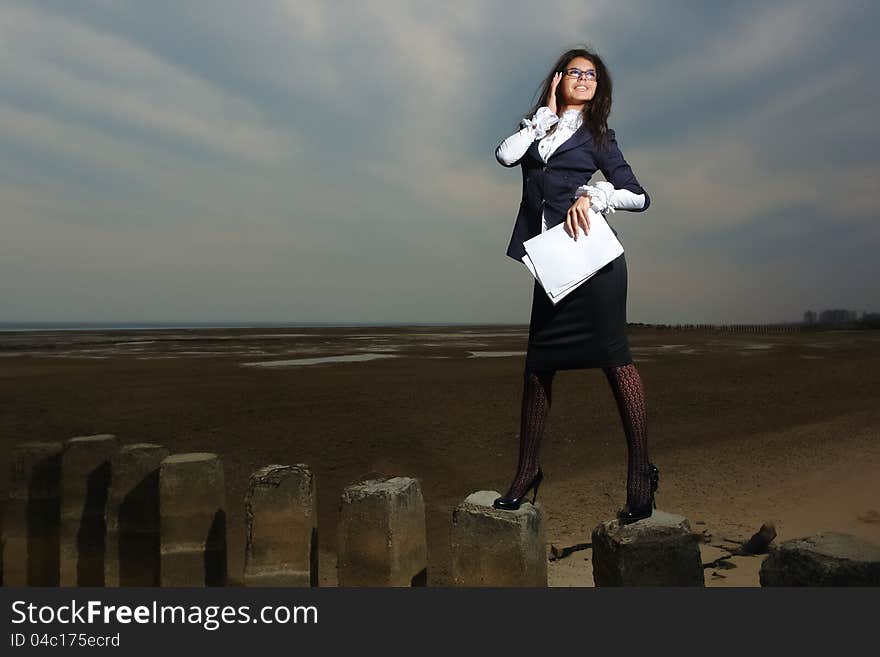 Business lady standing on the beach, on a backgrou