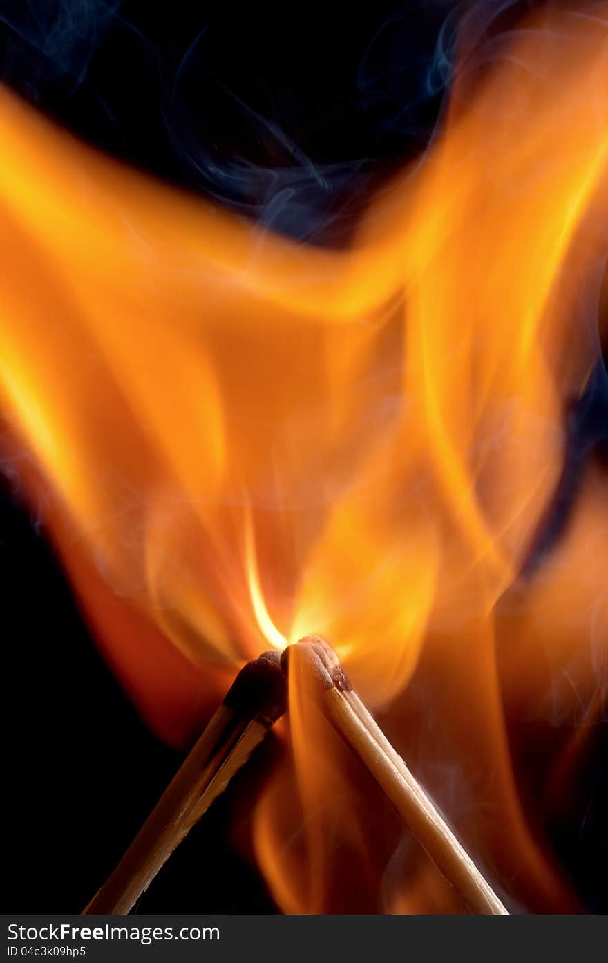 Burning matchstick on black background