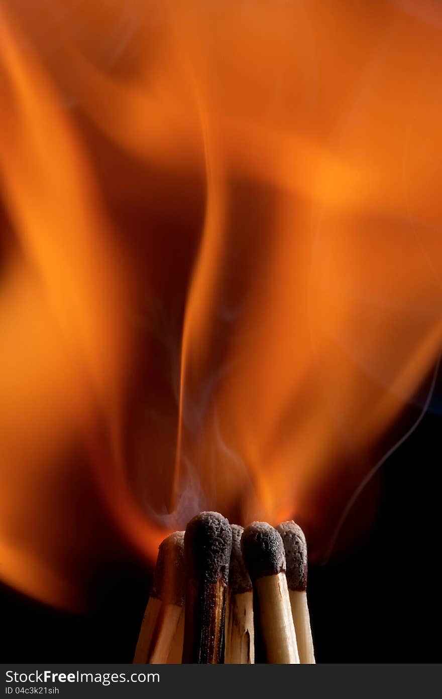 Burning matchstick on black background