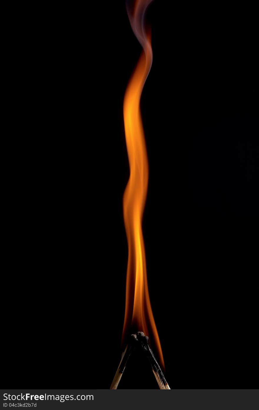 Burning matchstick on black background