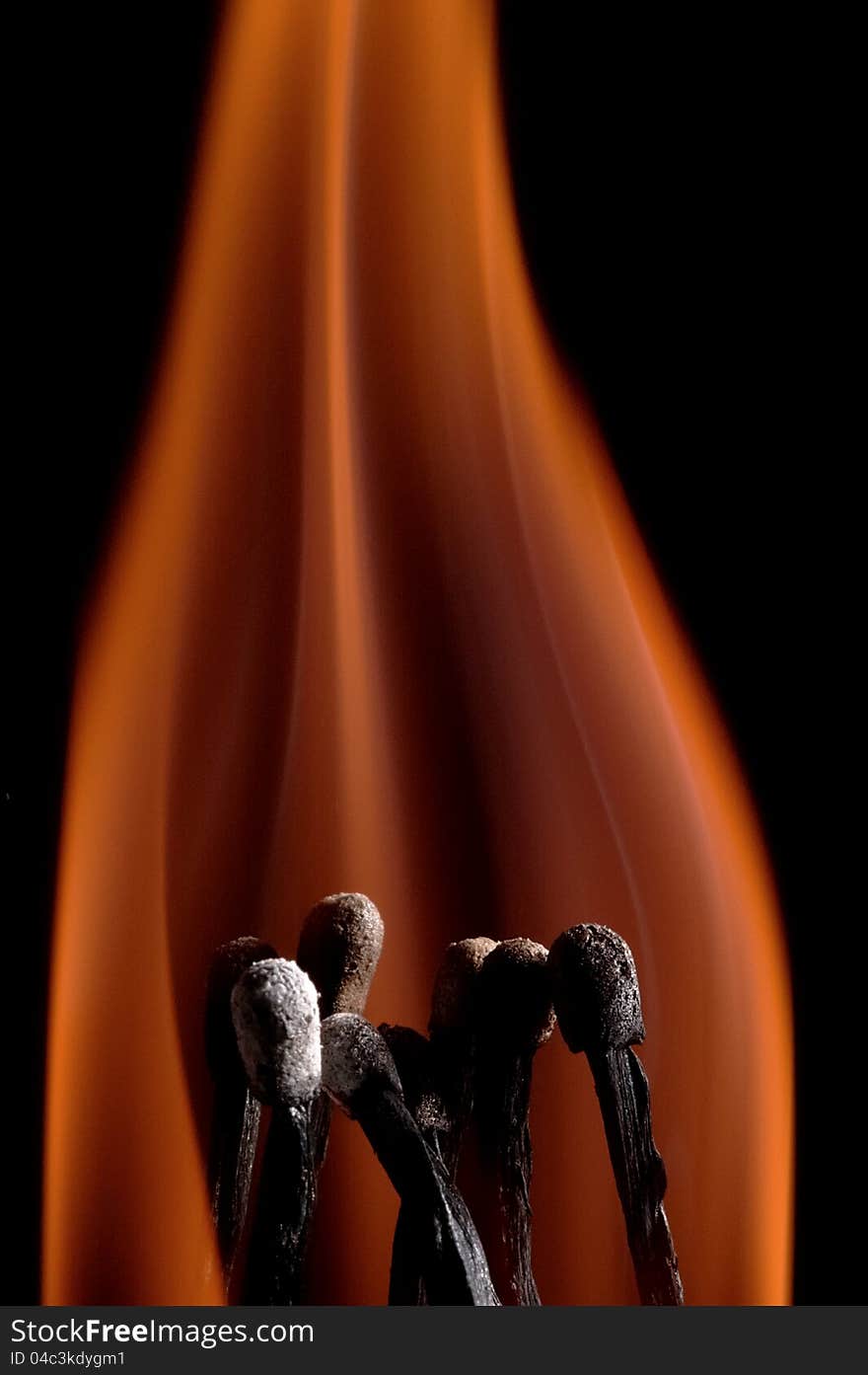 Burning matchstick on black background