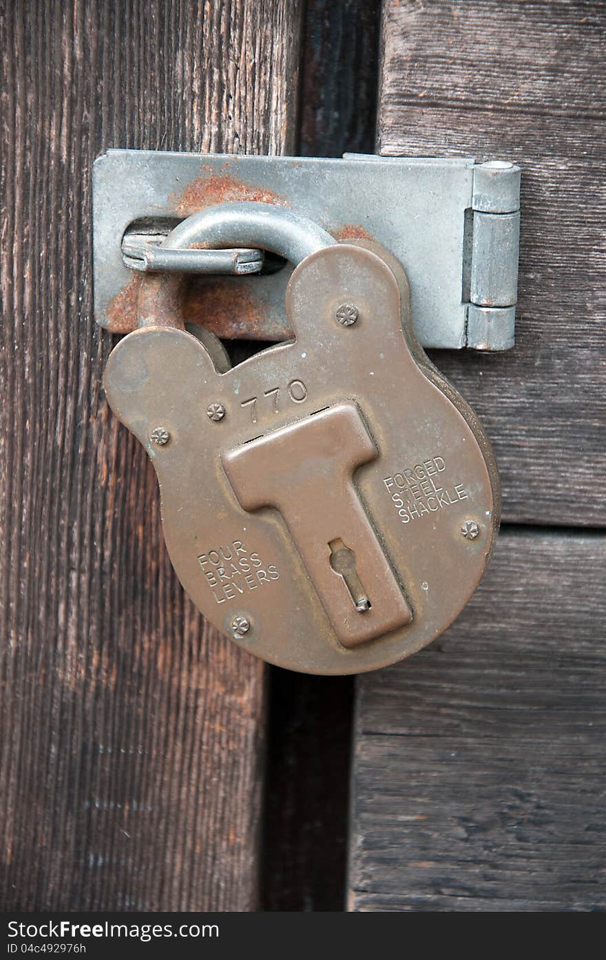 Old vintage locked Padlock on wooden gate