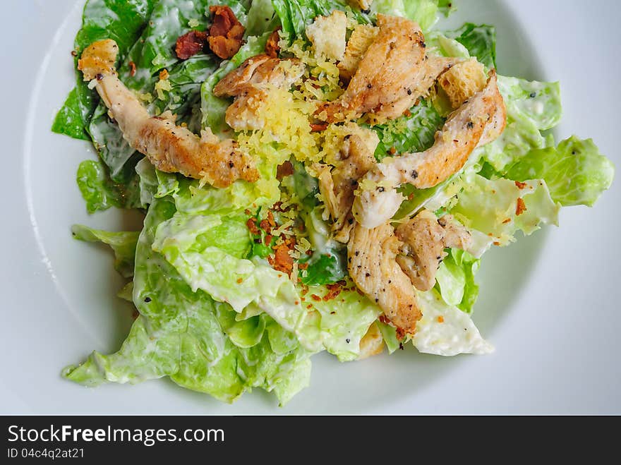 Close up top view of roast chicken salad in white plate