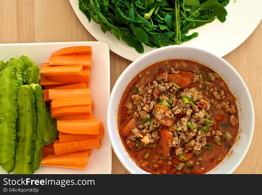 Thai style pork red curry with fresh vegetable on wood background. Thai style pork red curry with fresh vegetable on wood background