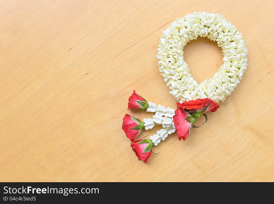 Traditional thai style white and red flower garland on wood background. Traditional thai style white and red flower garland on wood background