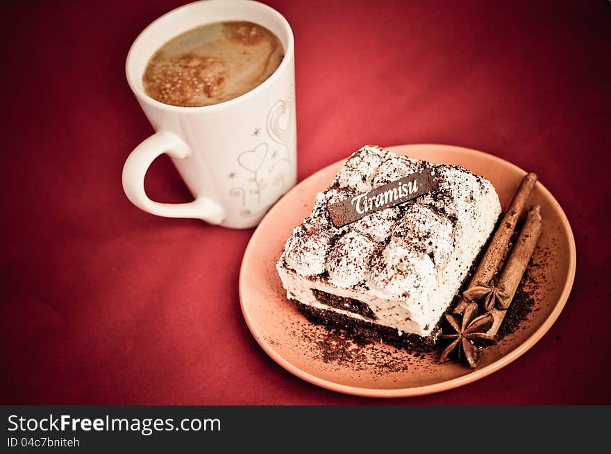 Classic tiramisu with stick of cinnamon and stars of anise on a plate. Classic tiramisu with stick of cinnamon and stars of anise on a plate