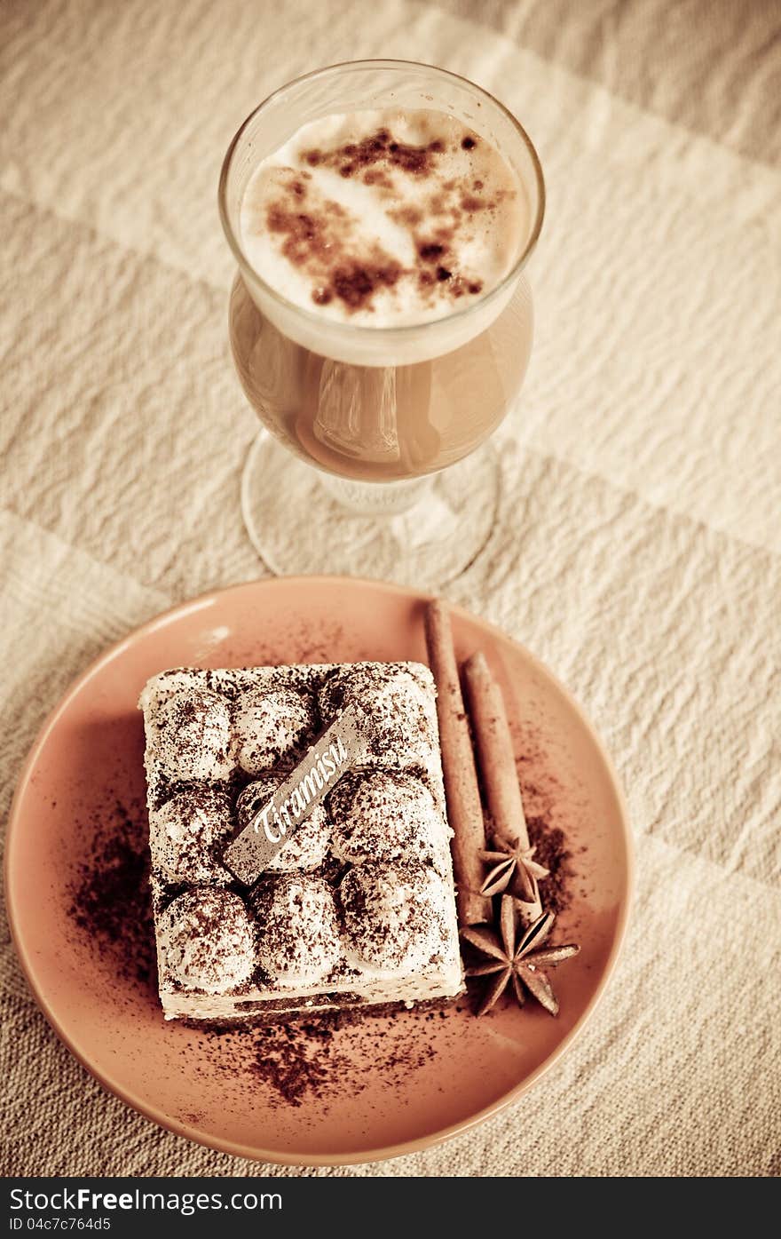 Classic tiramisu with stick of cinnamon and stars of anise on a plate. Classic tiramisu with stick of cinnamon and stars of anise on a plate